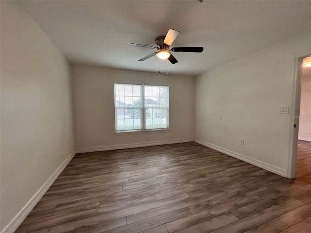 unfurnished room with ceiling fan and dark hardwood / wood-style flooring