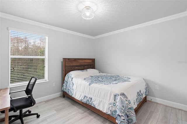 bedroom with light wood-type flooring, ornamental molding, and a textured ceiling