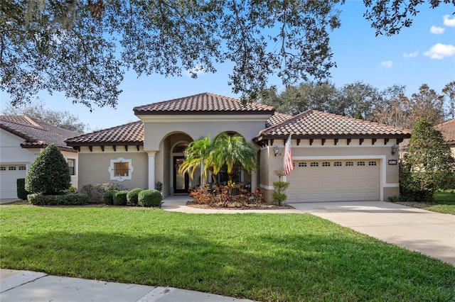 mediterranean / spanish home featuring a front lawn and a garage