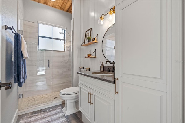 bathroom featuring toilet, vanity, a shower with shower door, and wood-type flooring