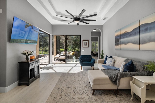 living room featuring ceiling fan, plenty of natural light, and light wood-type flooring