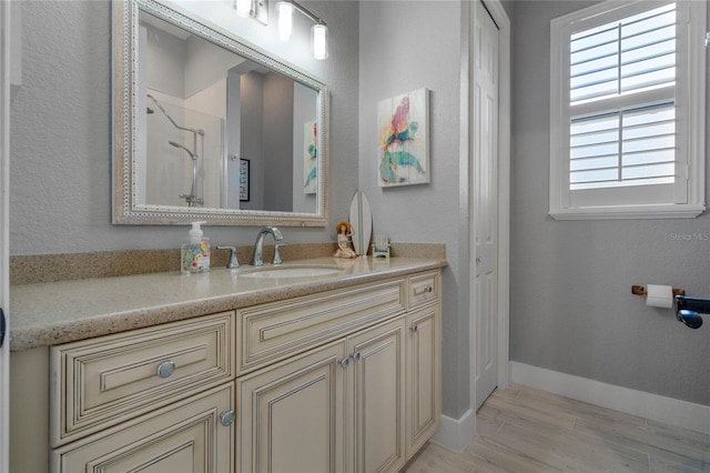 bathroom featuring a shower, vanity, and hardwood / wood-style flooring