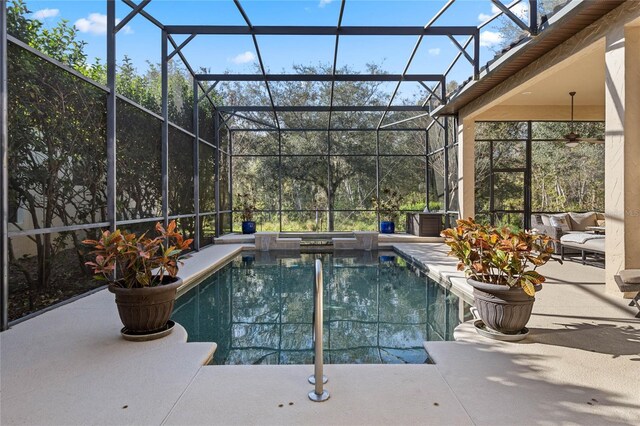 view of pool with glass enclosure and a patio area