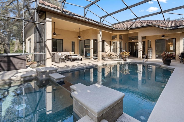 view of pool with a jacuzzi, outdoor lounge area, ceiling fan, glass enclosure, and a patio