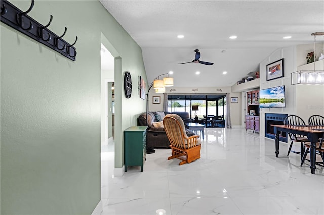 living room featuring a textured ceiling, ceiling fan, and lofted ceiling