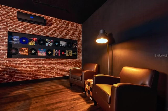 living area with wood-type flooring and brick wall