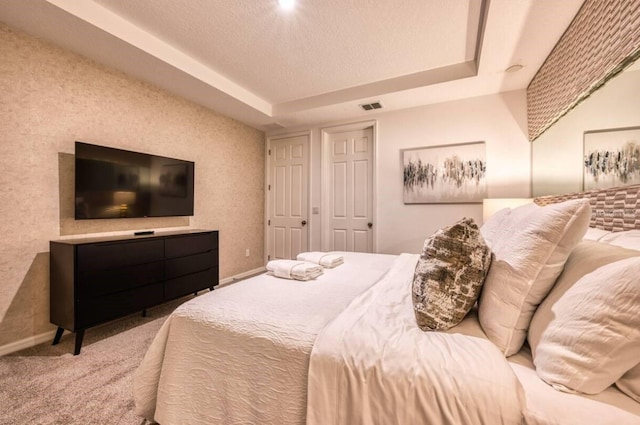 bedroom featuring a tray ceiling and carpet