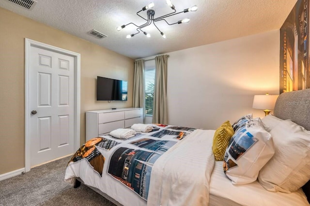 carpeted bedroom featuring a textured ceiling and a chandelier