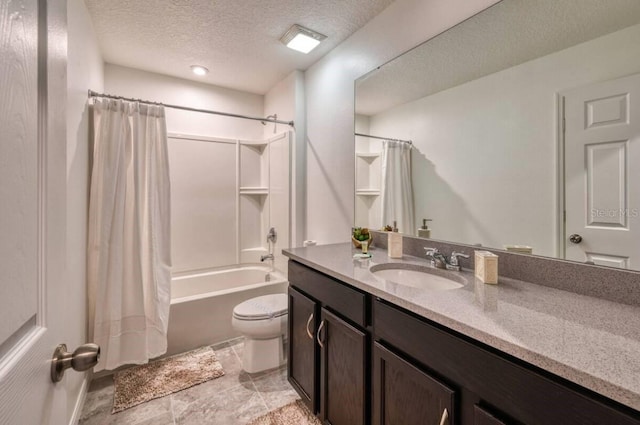 full bathroom featuring shower / bath combo with shower curtain, vanity, a textured ceiling, and toilet