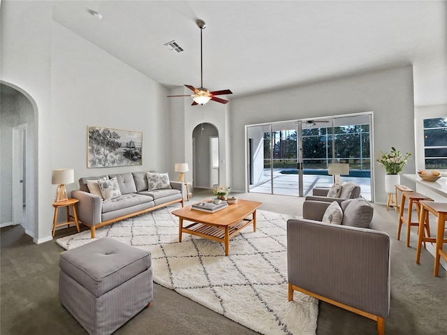 living room with carpet, a towering ceiling, and ceiling fan