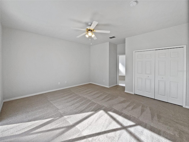 unfurnished bedroom featuring carpet, ceiling fan, and a closet