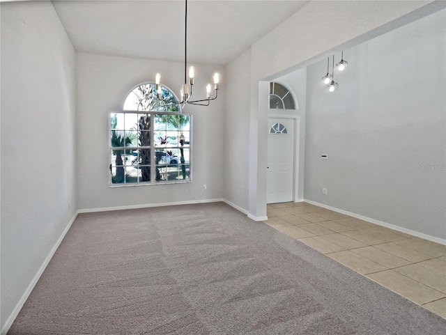 spare room with tile patterned floors and an inviting chandelier