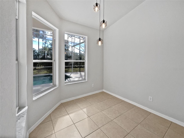 unfurnished dining area featuring light tile patterned floors and vaulted ceiling