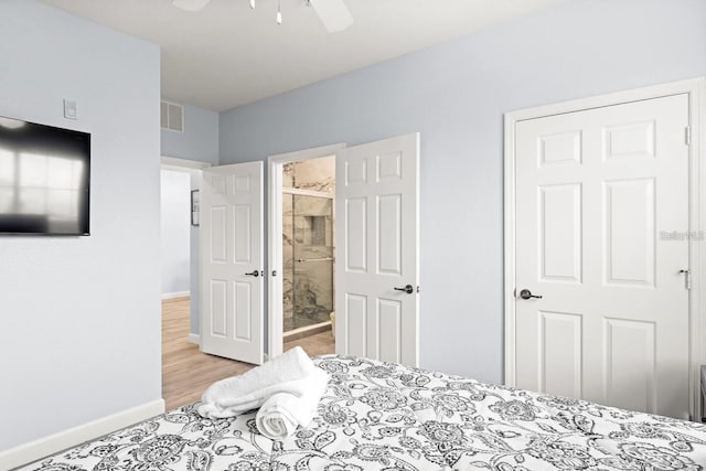 bedroom with ensuite bathroom, light wood-type flooring, and ceiling fan