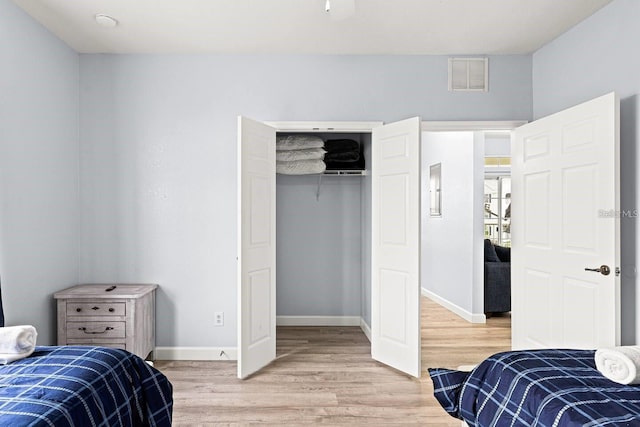 bedroom with light hardwood / wood-style flooring and a closet