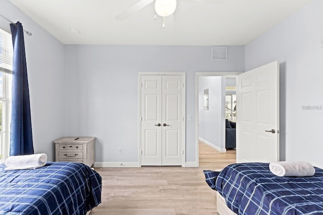 bedroom with hardwood / wood-style floors, ceiling fan, and a closet