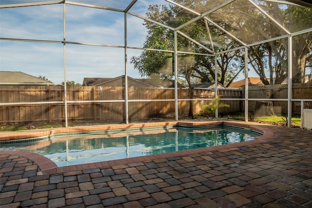 view of pool featuring glass enclosure and a patio area