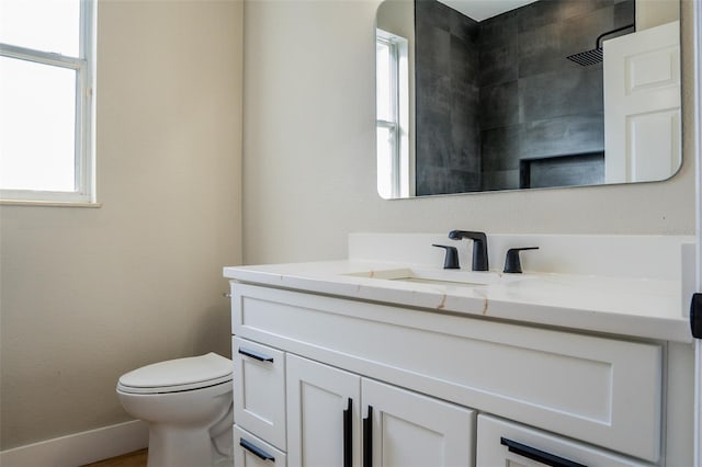 bathroom featuring walk in shower, vanity, and toilet