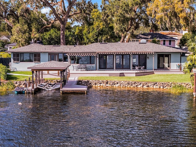 rear view of house with a lawn and a water view