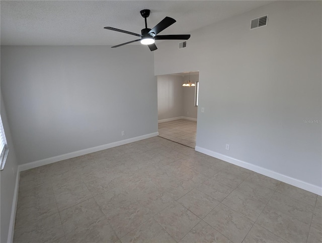 spare room featuring ceiling fan with notable chandelier, lofted ceiling, and a textured ceiling