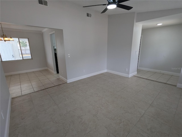 tiled spare room with ceiling fan with notable chandelier and crown molding