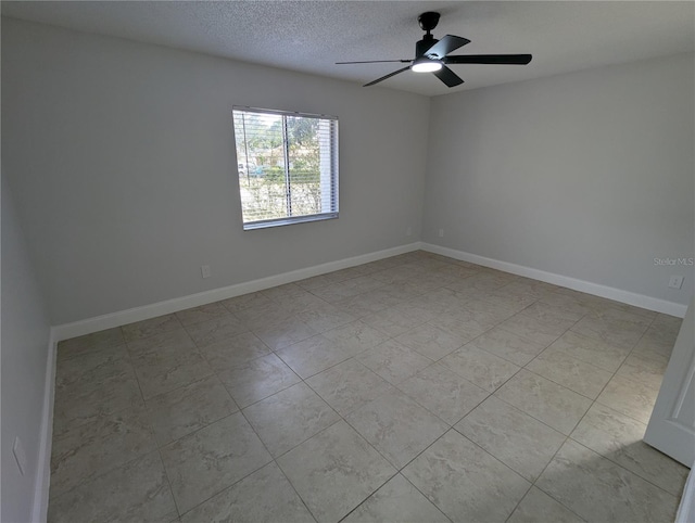 tiled empty room featuring ceiling fan and a textured ceiling