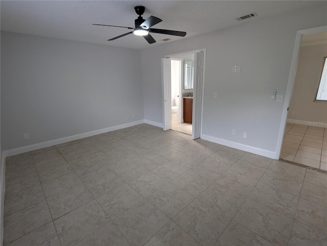 tiled empty room featuring a textured ceiling and ceiling fan