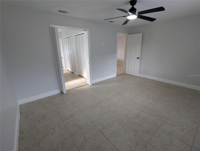 empty room with a textured ceiling and ceiling fan