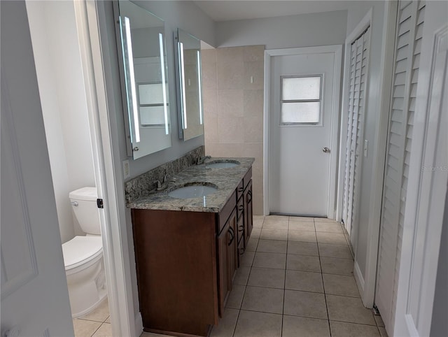 bathroom with tile patterned flooring, vanity, and toilet