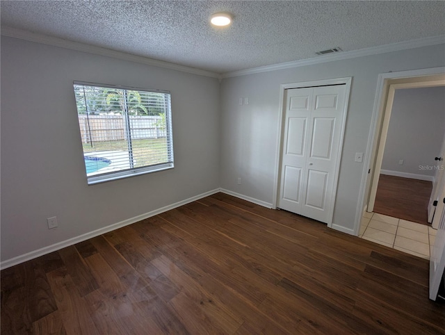 unfurnished bedroom with a closet, dark wood-type flooring, and a textured ceiling