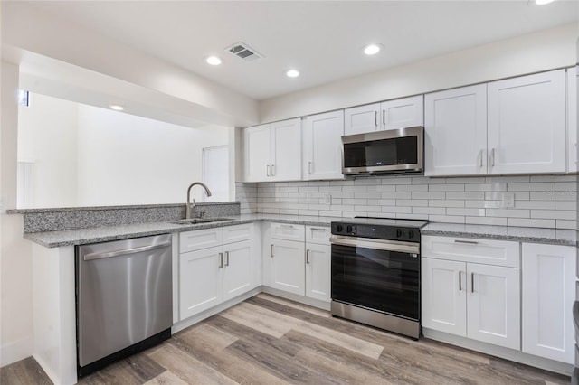 kitchen featuring white cabinetry, appliances with stainless steel finishes, sink, and light wood-type flooring