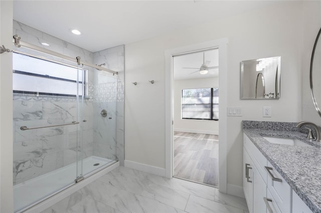 bathroom featuring ceiling fan, vanity, and a shower with door