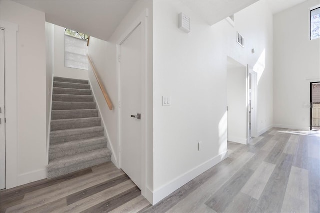 stairway featuring hardwood / wood-style floors and a wealth of natural light