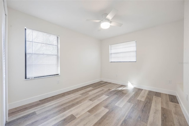 spare room with ceiling fan and light wood-type flooring