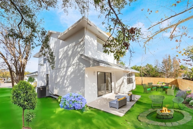 back of house featuring central AC unit, a lawn, an outdoor living space with a fire pit, and a patio