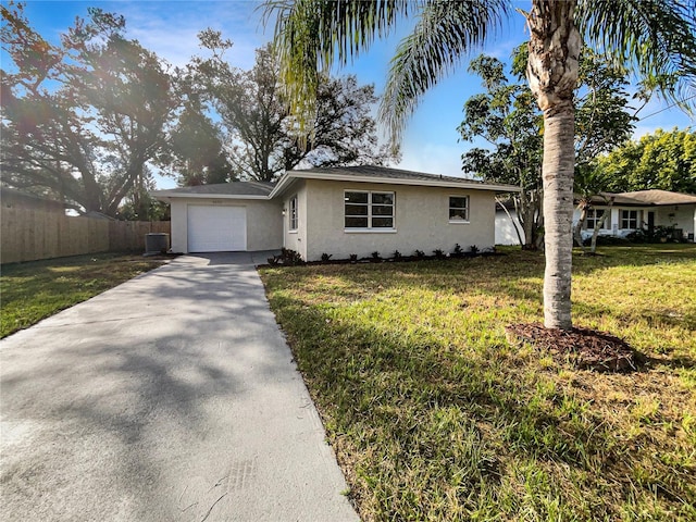 ranch-style home featuring cooling unit, a front lawn, and a garage