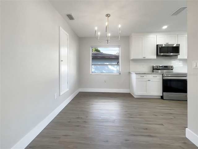 kitchen featuring white cabinetry, hanging light fixtures, an inviting chandelier, tasteful backsplash, and appliances with stainless steel finishes