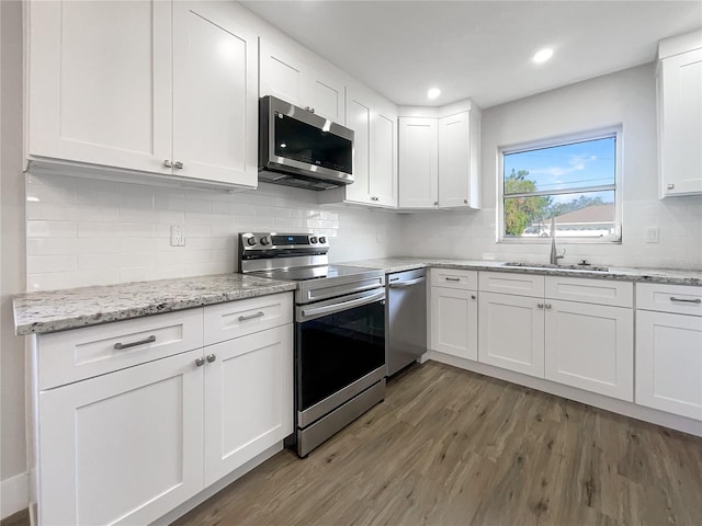 kitchen with white cabinets, appliances with stainless steel finishes, dark wood-type flooring, and sink