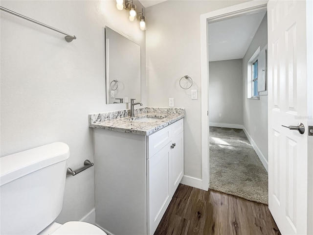 bathroom featuring vanity, wood-type flooring, and toilet