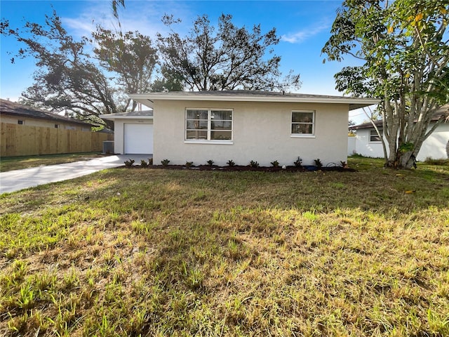 ranch-style house featuring a garage and a front lawn