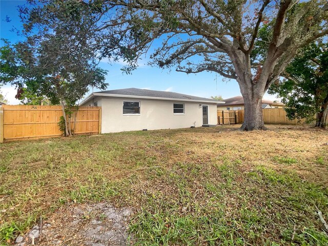 rear view of house featuring a lawn