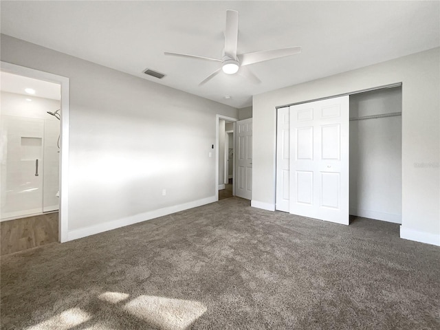 unfurnished bedroom with ceiling fan, dark carpet, ensuite bath, and a closet