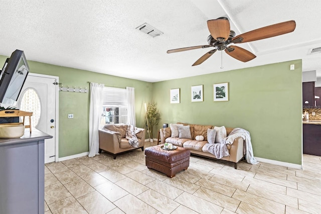 living room with a textured ceiling and ceiling fan