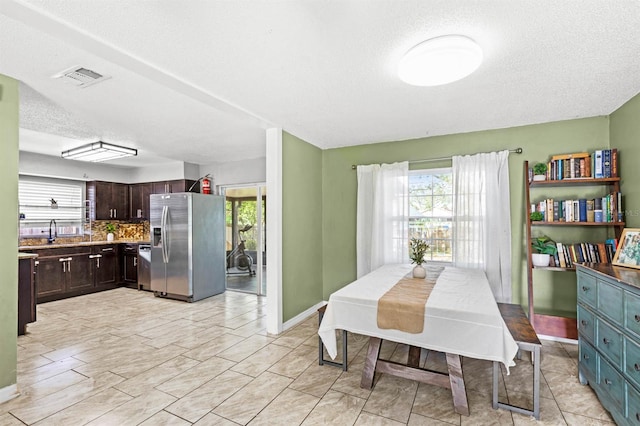 dining area with a textured ceiling and sink