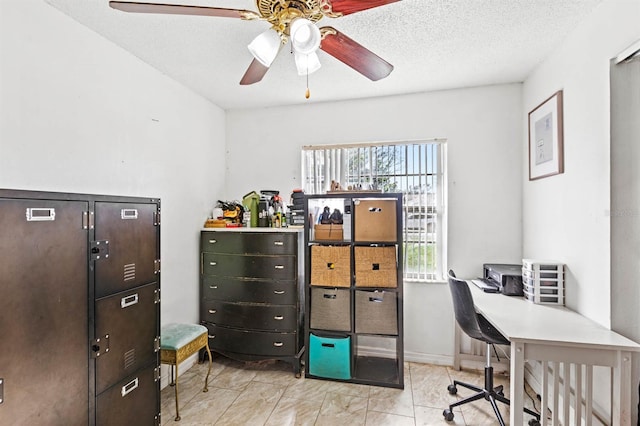 tiled office space featuring a textured ceiling and ceiling fan