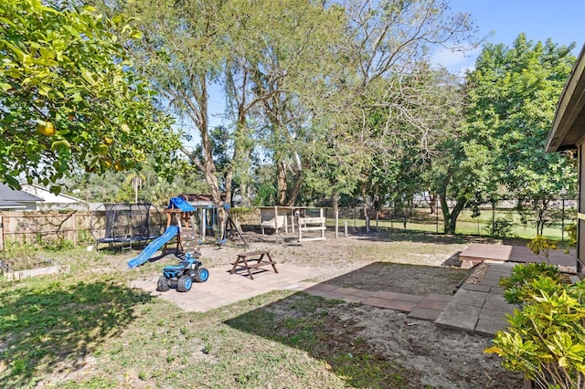 view of yard with a playground, a trampoline, and a patio