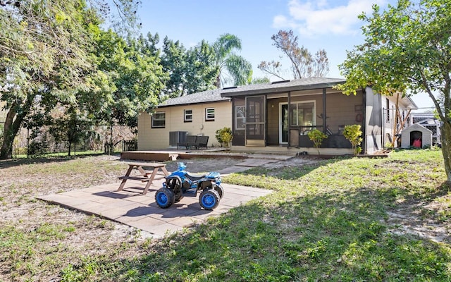 rear view of property featuring a patio, central air condition unit, and a sunroom