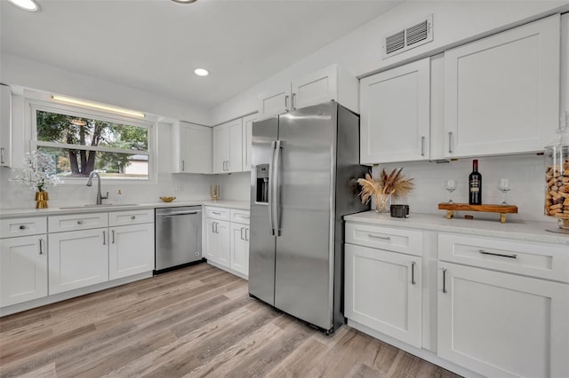 kitchen featuring white cabinetry, appliances with stainless steel finishes, sink, and backsplash