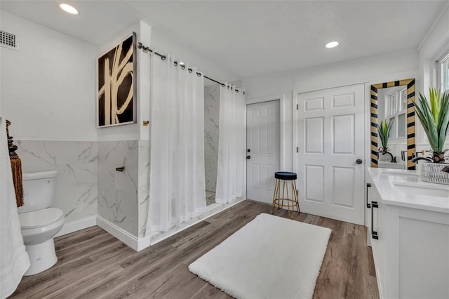 bathroom with hardwood / wood-style floors, vanity, curtained shower, and toilet