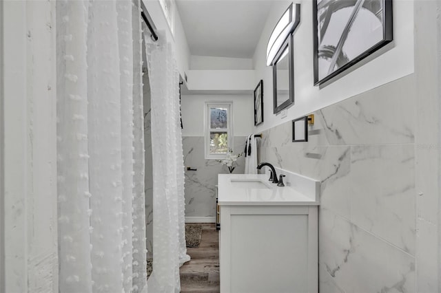bathroom with tile walls, vanity, and hardwood / wood-style flooring